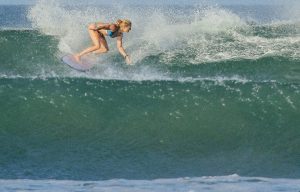 Girl surfing Playa Guiones, Costa Rica.